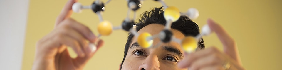 Young man examining molecular model