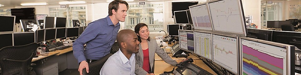 Staff on the Trading Floor examine data on multi computer screens