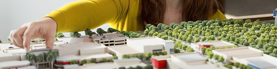 Caucasian businesswoman examining scale model