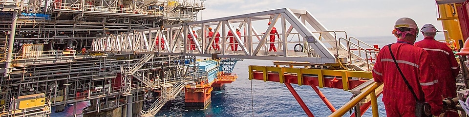 Workers cross over to a new platform built alongside the existing Malampaya deep-water project